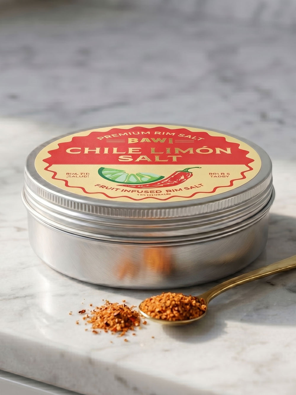 Tin of Chile Limón salt with a spoonful of salt on a marble surface